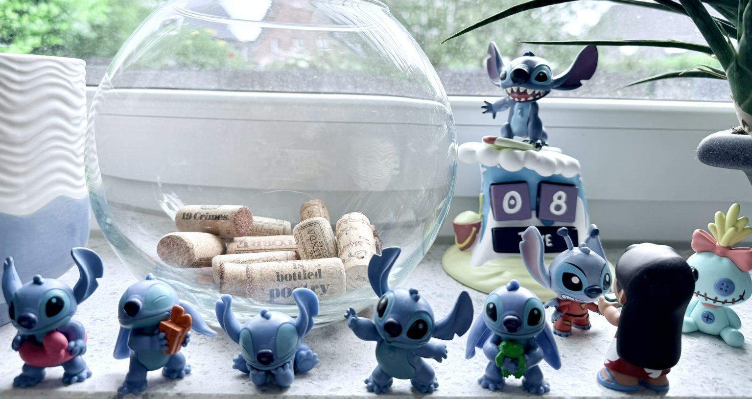 Stitch-Figuren und eine Glasschale mit Weinkorken auf einer Fensterbank