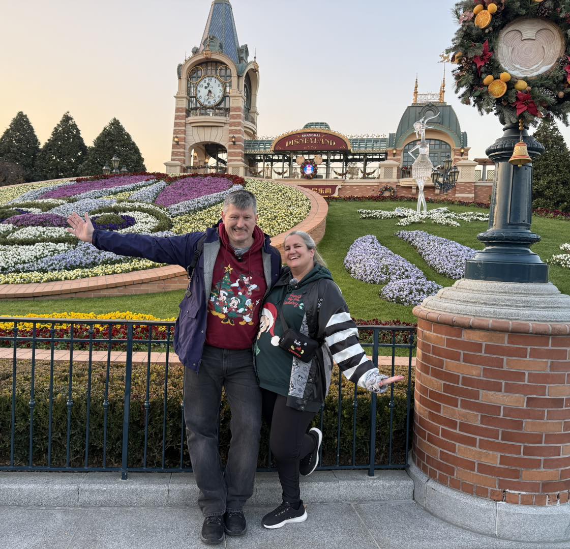 Mausgecheckt vor dem Eingang von Shanghai Disneyland mit Mickey-Blumenbeet und weihnachtlicher Dekoration